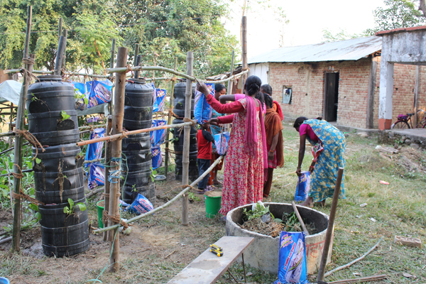Efter havemanden Raju Basals ide, lavede vi også et stakit foran tønderne sådan at vi kunne lægge plastik-dug over for at beskytte mod sol og regn.